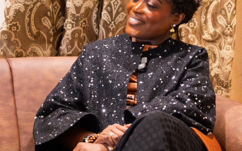 Dr. Adaeze Oreh — Working engagement — seated on brown leather couch